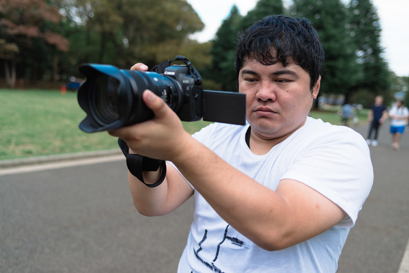 バリアングルモニター付きミラーレス一眼カメラで撮影する男性カメラマン［モデル：段田隼人］