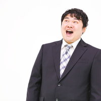 スーツ姿で笑ってごまかす会社員の営業トークの写真