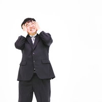 なんてこった、やってもうた。頭を抱える男性サラリーマンの写真