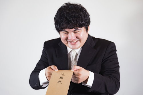 退職届を手にした笑顔の男性会社員が新たなキャリアへ踏み出す瞬間