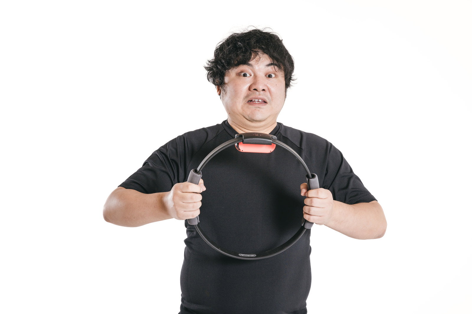 黒いTシャツの男性がリングを両手で握ってトレーニングしている［モデル：段田隼人］