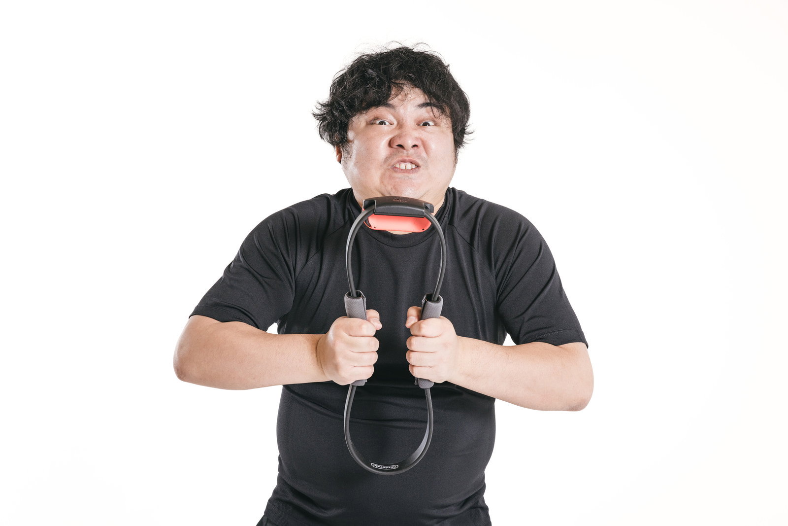 リングコンを両手で押し潰して力を込める男性［モデル：段田隼人］