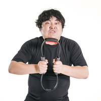 リングコンを力いっぱい押し潰す男性のトレーニング風景の写真