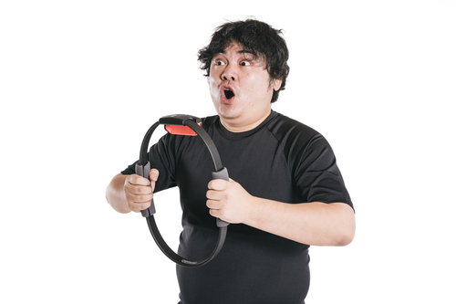 黒いシャツを着た男性がリングの輪を力いっぱい引っ張る