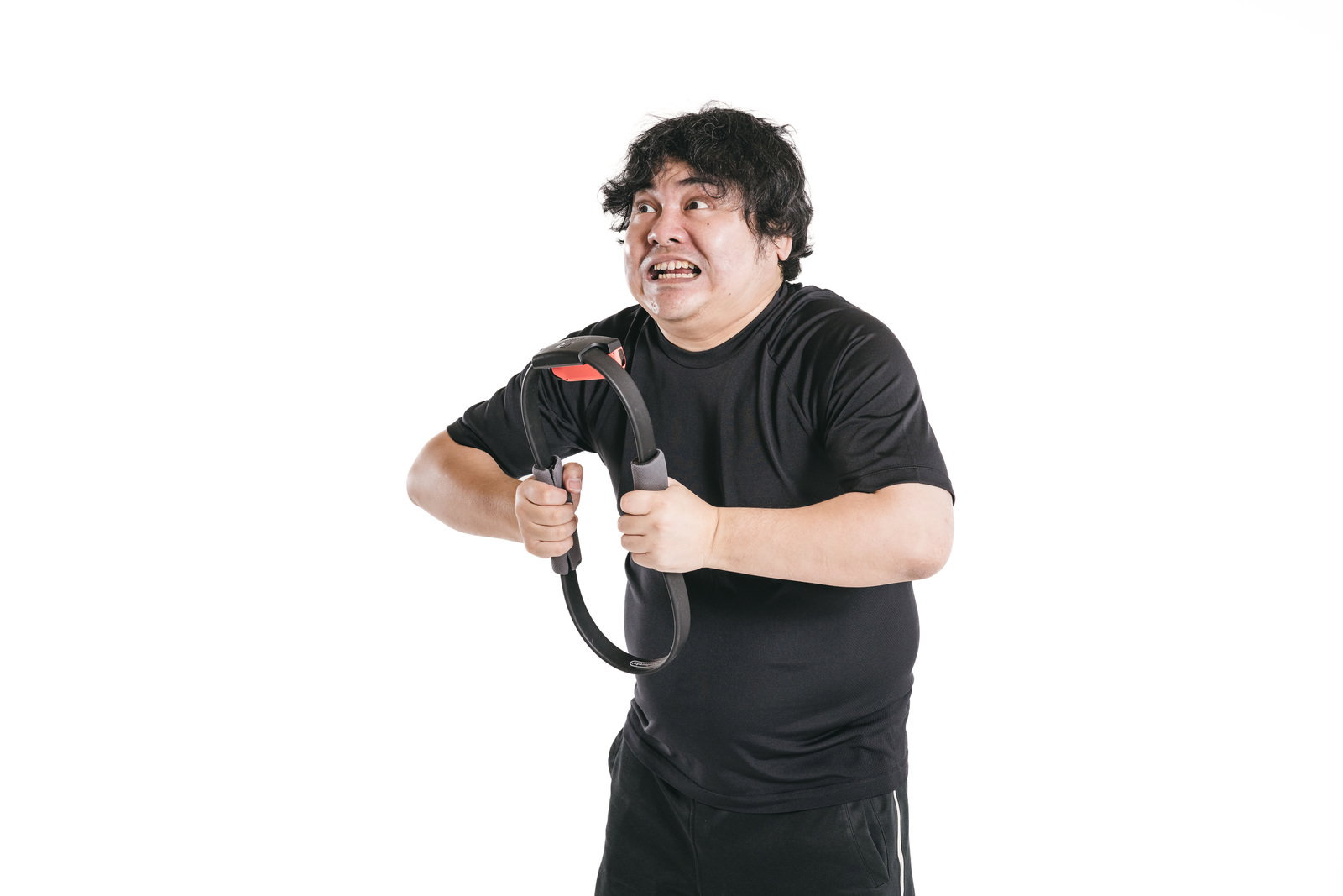 リングコンを両手で力いっぱい押し潰すゲーム中の男性［モデル：段田隼人］