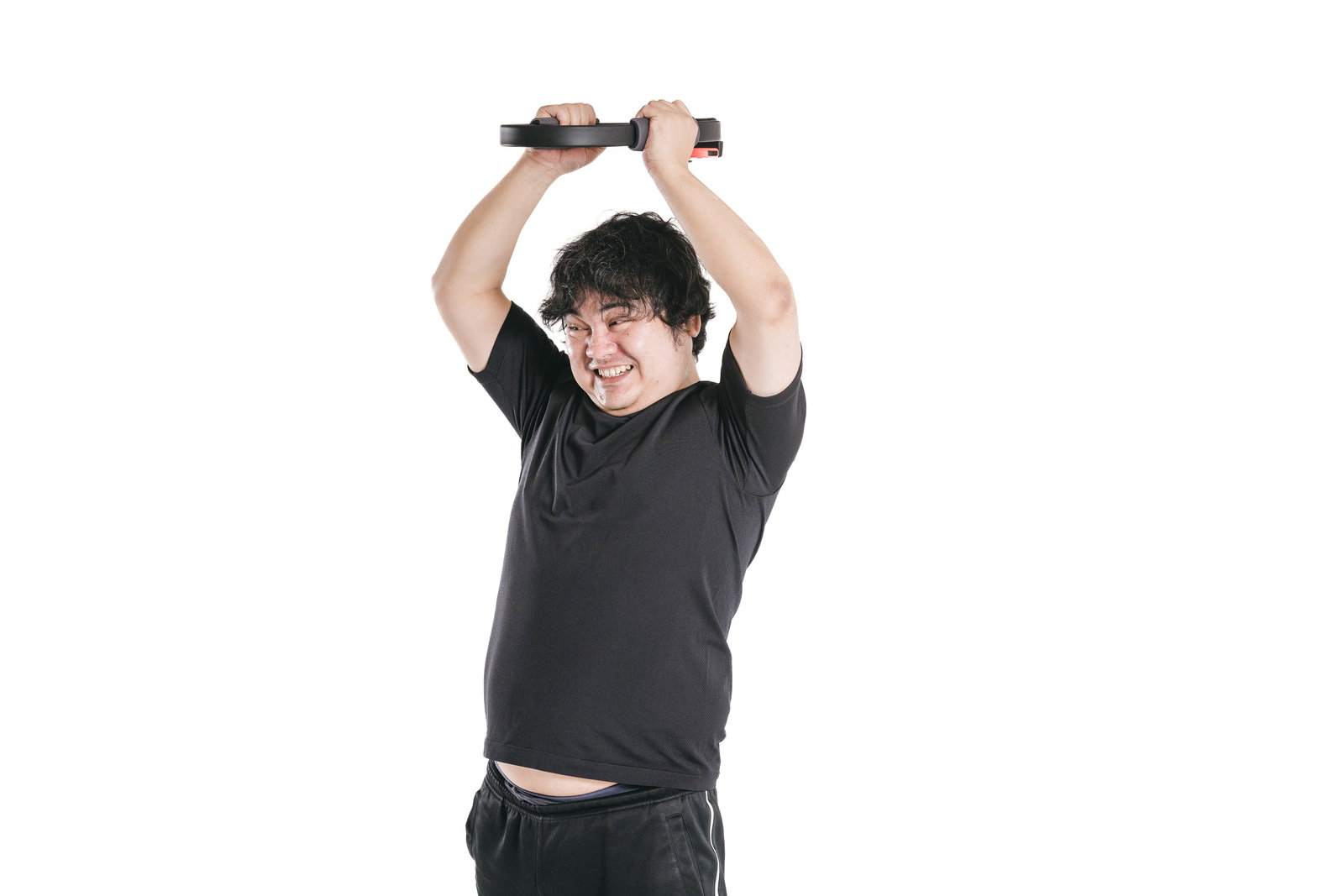 頭の上でリングコンを両手でプッシュしながらバンザイする男性［モデル：段田隼人］