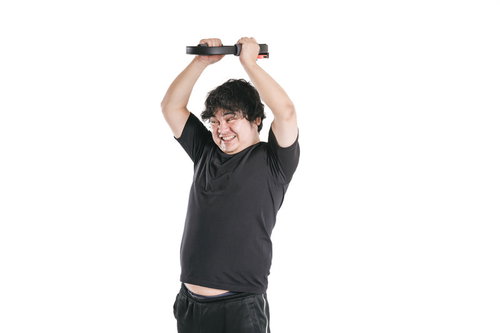 頭の上でリングコンをプッシュしながらバンザイする男性