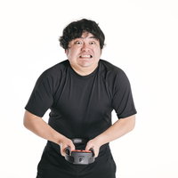 ゲームコントローラーを握ってムキになってプッシュする男性の写真
