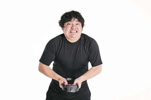 ゲームコントローラーを握ってムキになってプッシュする男性