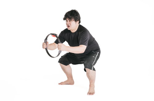 リングコンを使って腰を落とし脂肪燃焼中の男性