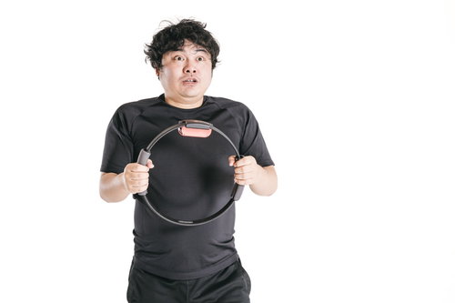 リングコンを握りしめてトレーニングする男性