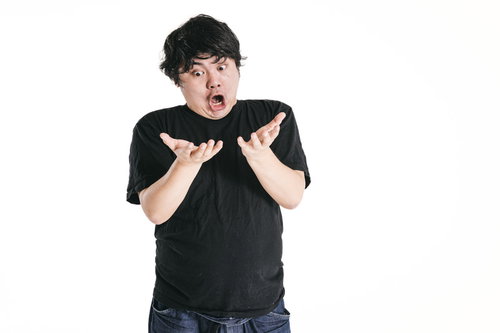 驚愕の感じる瞬間、両手を広げて驚く男性、黒いTシャツ姿