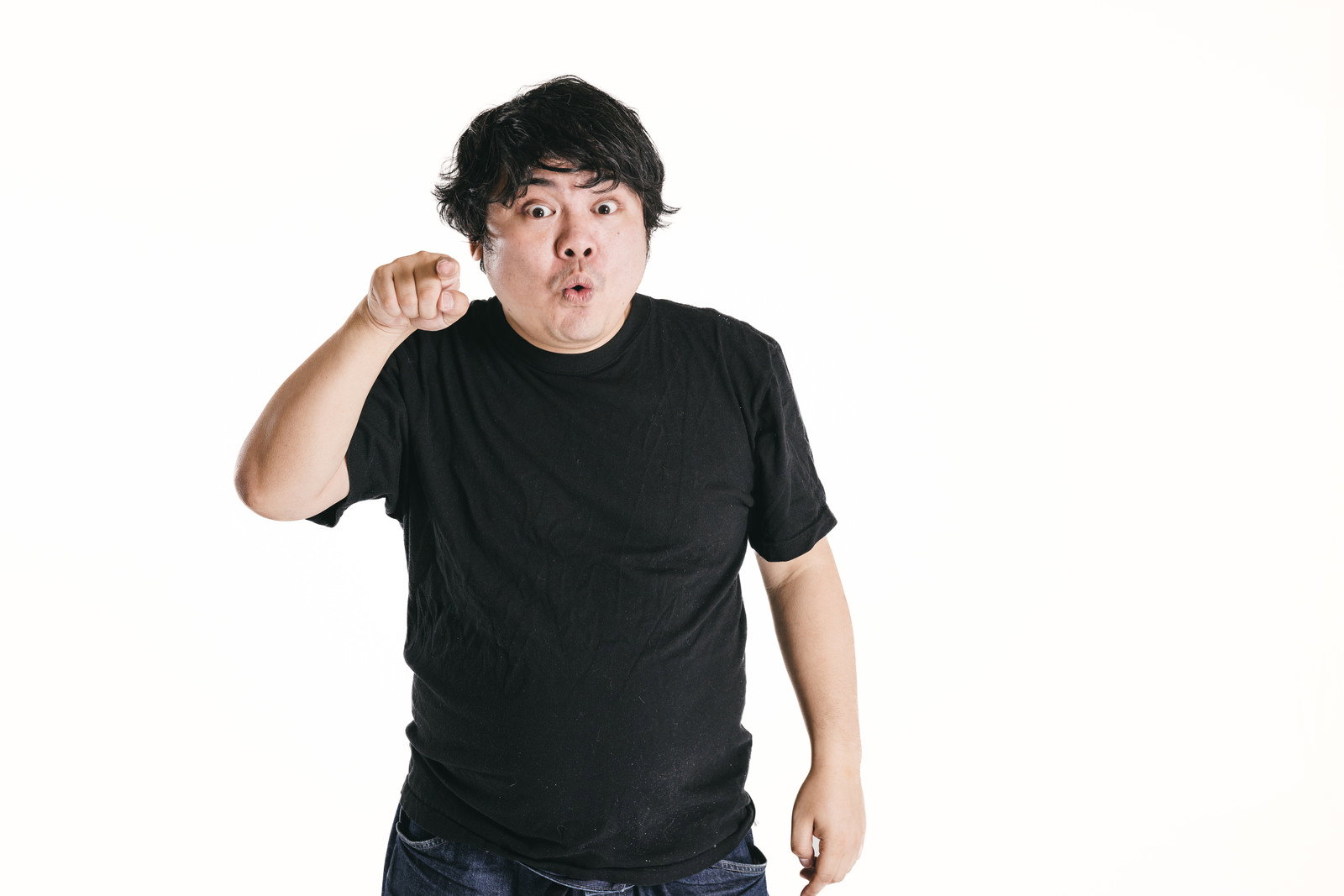 指をさして煽る表情を見せる男性［モデル：段田隼人］