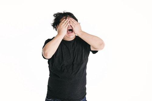 目を覆う男性の絶句する表情、後悔と悔しさを表現したショックの瞬間