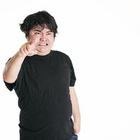 指をさして怒鳴り散らす黒いTシャツの男性の写真