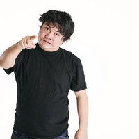 黒いTシャツの男性が指差しで威嚇する表情の写真