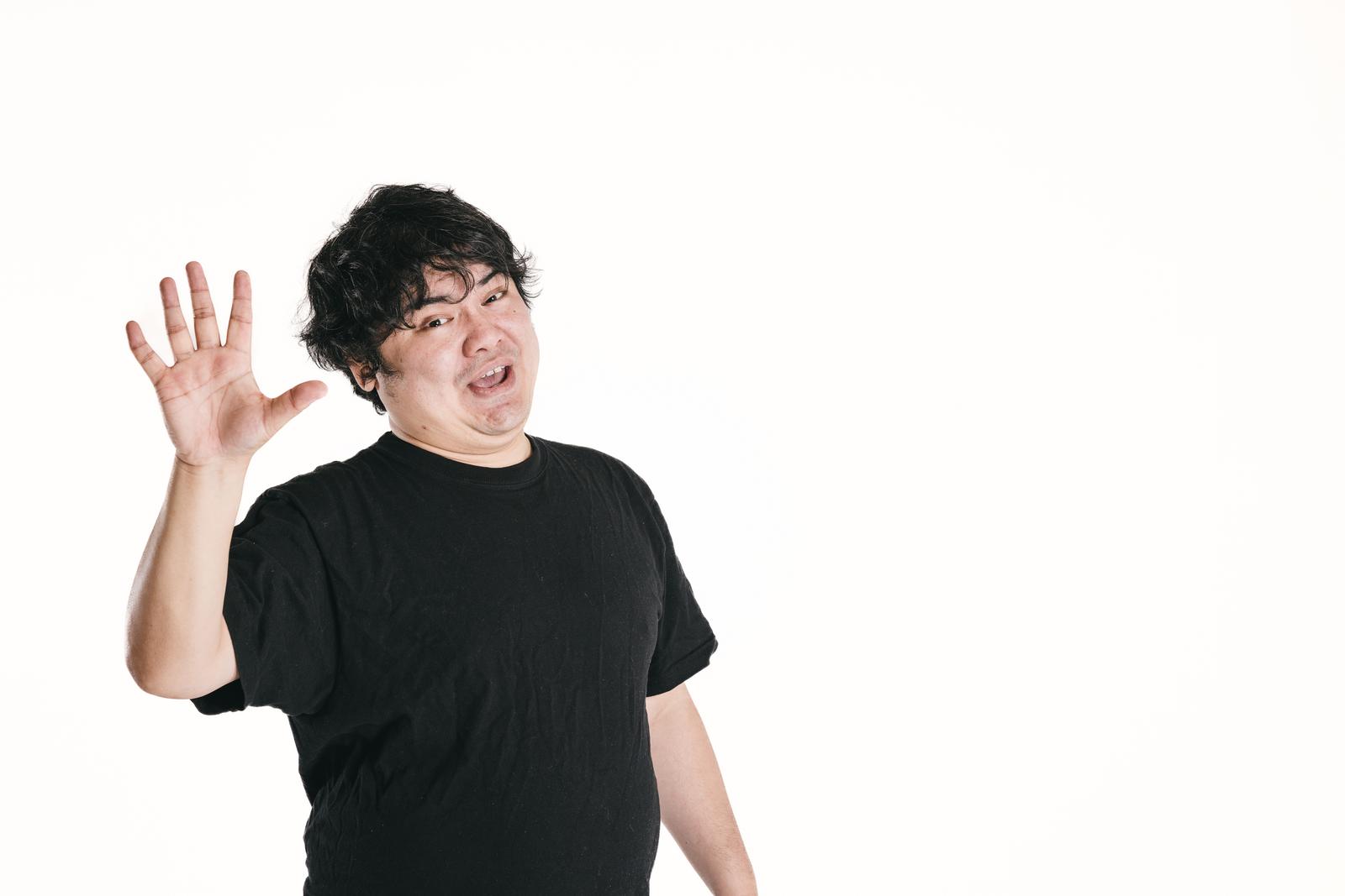 黒いシャツを着た男性が両手を上げてハンドサインで数字を表現している［モデル：段田隼人］