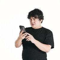 まじまじとスマートフォンを見つめ、考える男性の写真