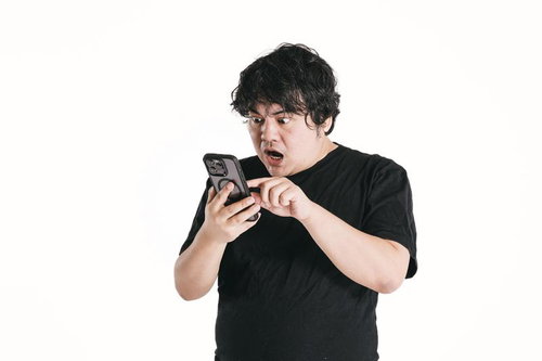 スマートフォンの画面を凝視して驚く男性の反応