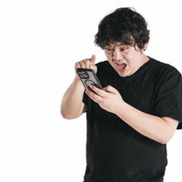 スマートフォンの画面に驚いて指を離す男性の写真
