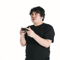 両手でゲームコントローラーを握りしめる男性の真剣な表情の写真