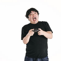 ゲームコントローラーを握りしめて驚きと興奮の表情を見せる男性の写真