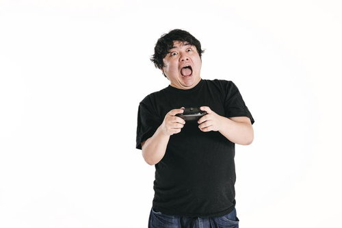 ゲームコントローラーを握りしめて驚きと興奮の表情を見せる男性