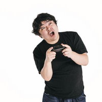 ゲームコントローラーを握りしめて驚く男性の写真