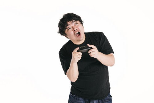 ゲームコントローラーを握りしめて驚く男性