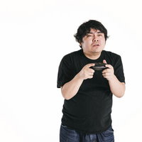細目でゲームコントローラーに没頭する男性の姿の写真