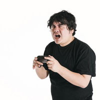 予期せぬ敗北に目を細めてゲームコントローラーを握る男性の写真