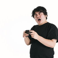 ゲームコントローラーを握り難しさに苦い表情の男性の写真