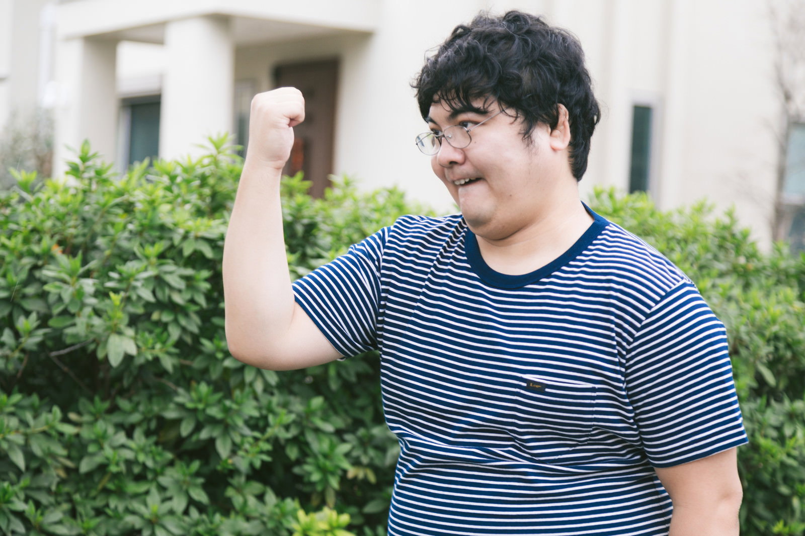 ボーダーTシャツを着てガッツポーズをする男性［モデル：段田隼人］