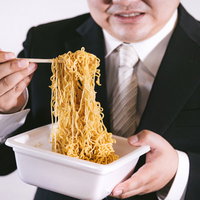 秘伝のソースを絡めるエンジニア男性のランチタイムの写真