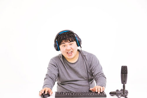 ヘッドセットをつけてパソコンでゲーム実況をする男性