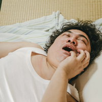 寝ながら指を食べるほど熟睡する親父の昼寝の写真