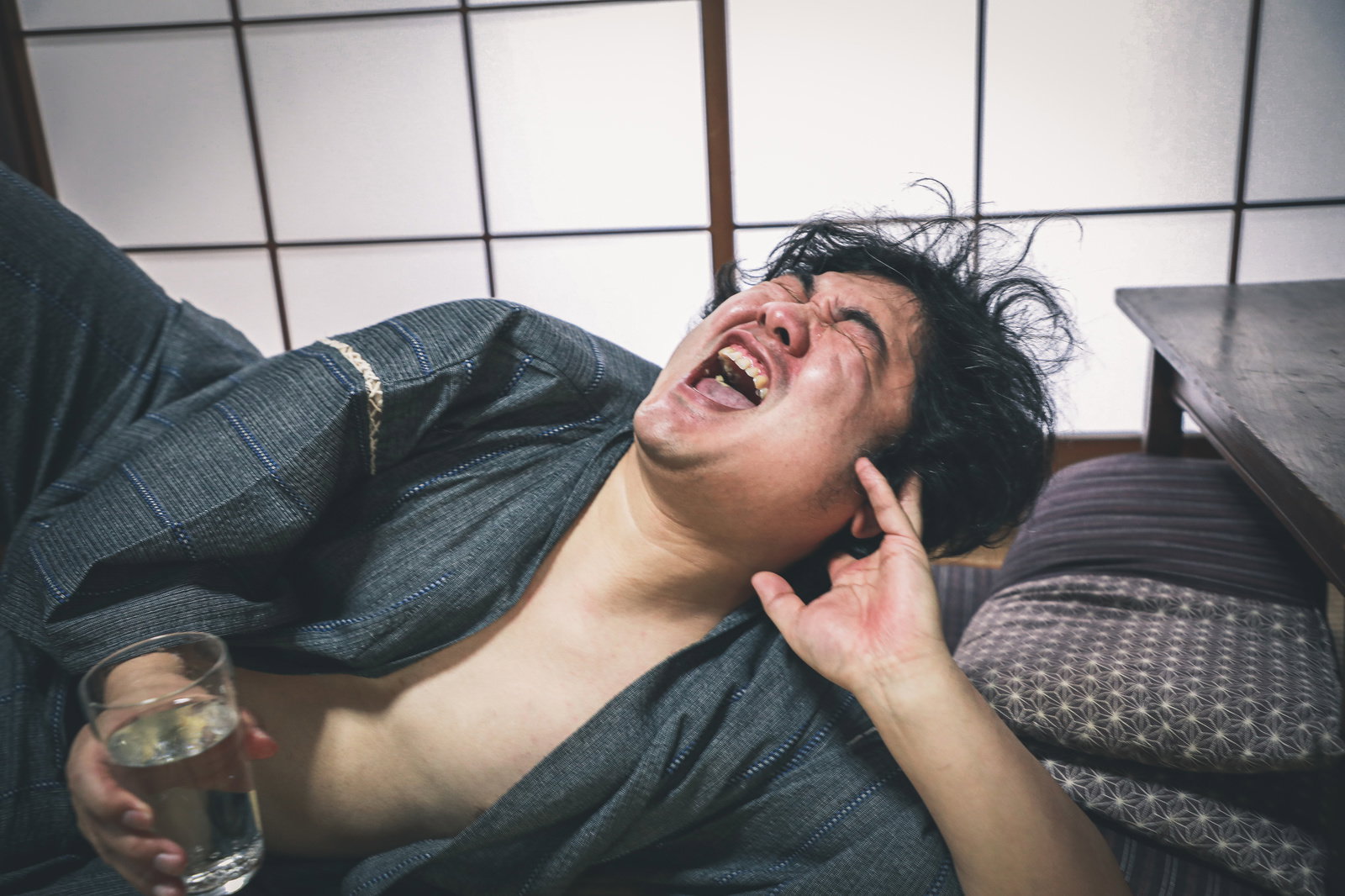水道水を飲んで喜んで叫ぶ男性が和室でくつろいでいる［モデル：段田隼人］