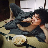 休日のブランチはコップ酒とポテチで満喫する男性の写真