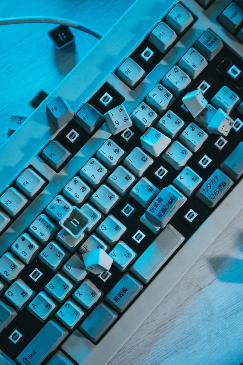 青い背景の上に置かれた破壊されたキーボード