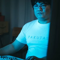 モニターの明かりで淡々と作業するエンジニア、キーボードクラッシャーの写真