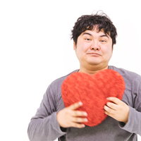 赤いハートを胸に抱きしめるぎこちない男性の写真