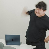 パソコンの前で怒っている男性の写真