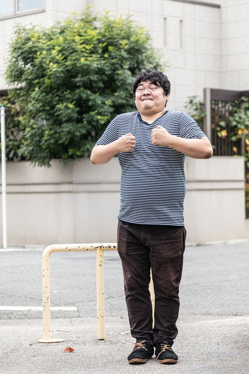 握り拳をにぎって歯を食いしばり踏ん張るメガネ男子