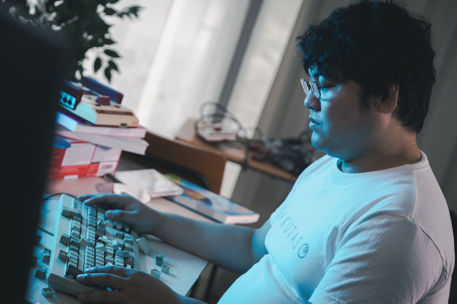 壊れたキーボードの前で放心状態になっている男性［モデル：段田隼人］