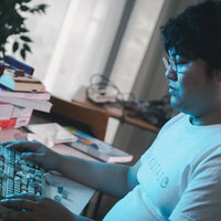 壊れたキーボードを前に放心状態の男性エンジニアの写真