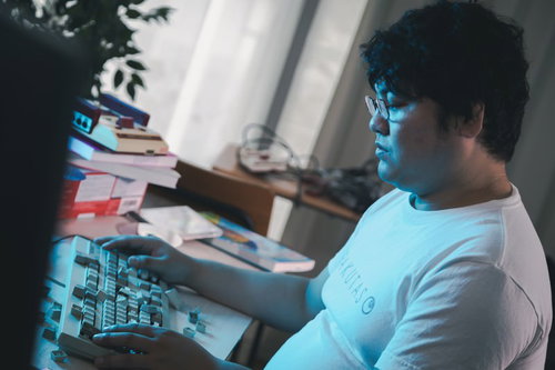 壊れたキーボードを前に放心状態の男性エンジニア