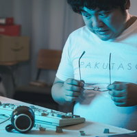 正気を取り戻して破壊したキーボードを眺める男性の写真