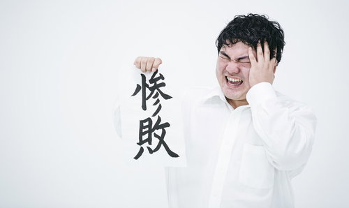 悔しいけど惨敗、頭を抱える男性の敗北と落胆の表情