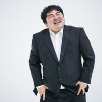 ニヤニヤ笑ってごまかすビジネスマンの写真