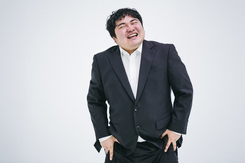 ニヤニヤ笑ってごまかすビジネスマン